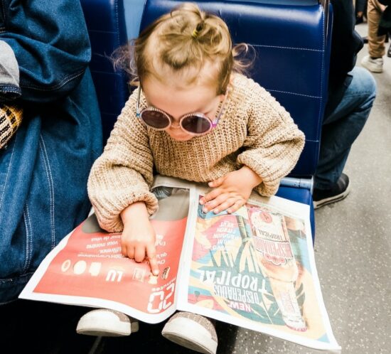 Kind zeigt auf Bild in Zeitung